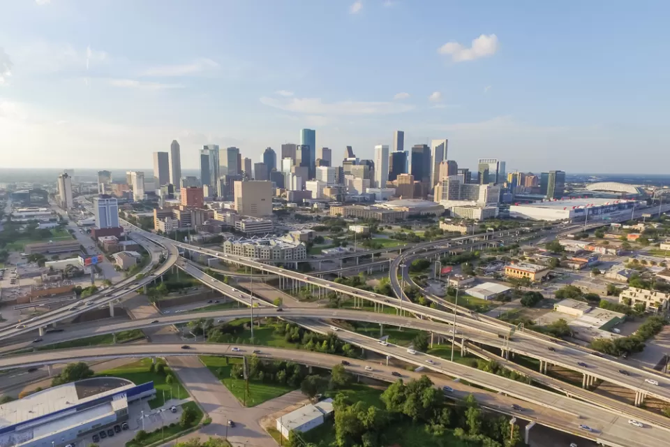 Aerial view of Houston freeway interchanges with downtown skyline in background
